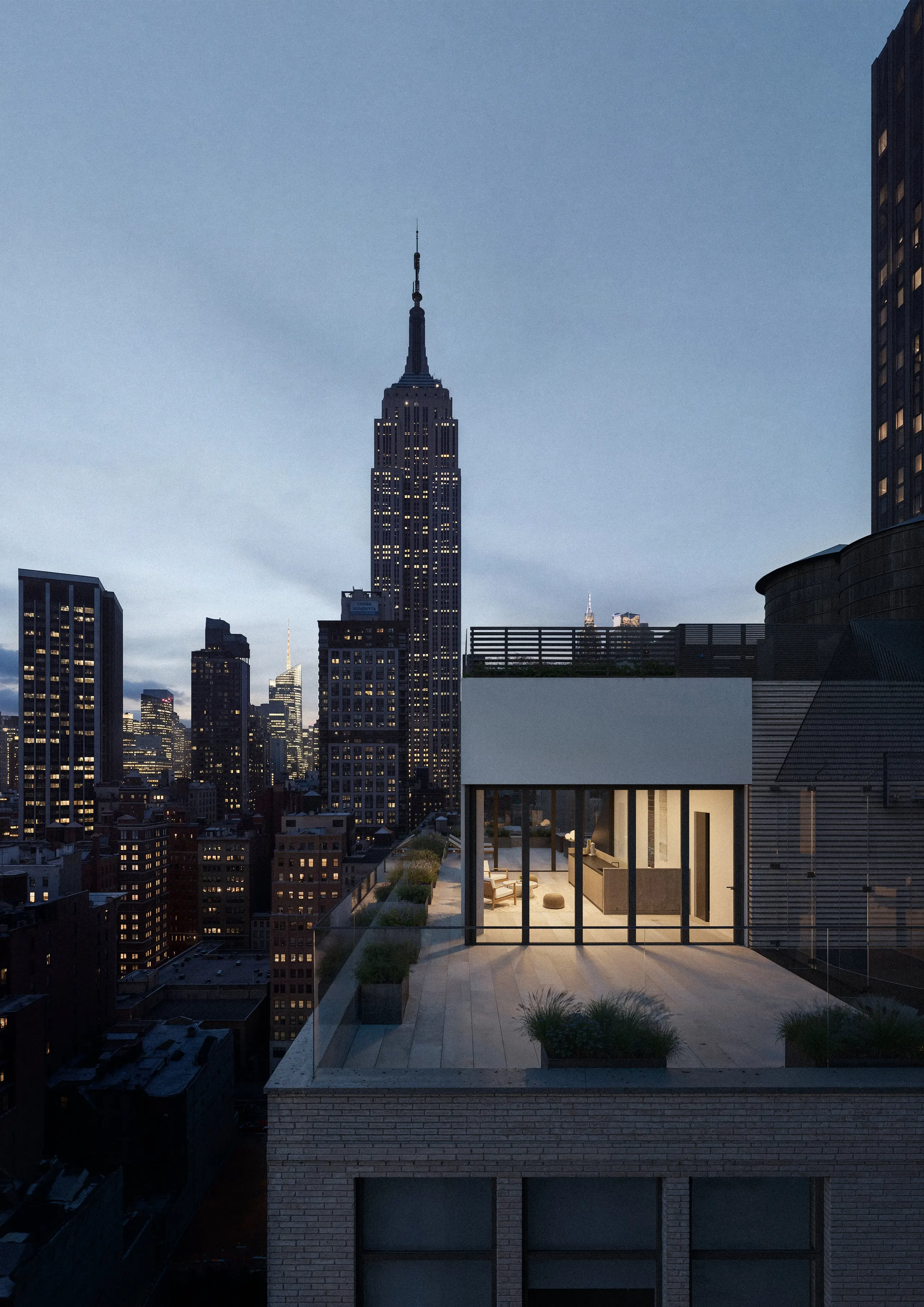 Aerial view of the penthouse terrace at dusk with the Empire State Building behind